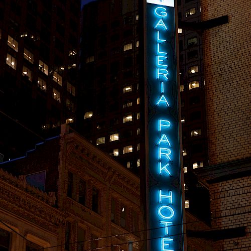 This image shows a neon-lit vertical sign for 