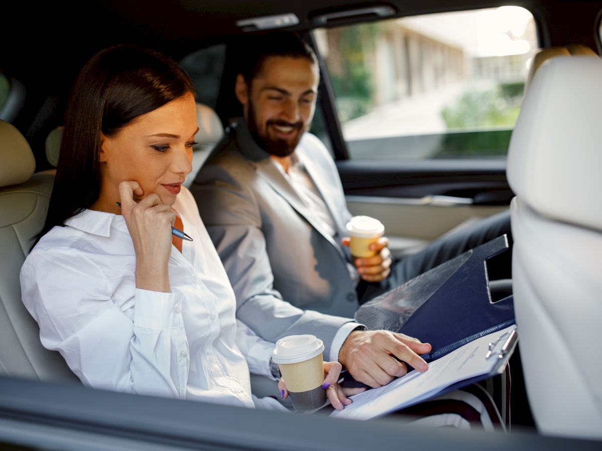 man and woman working in car