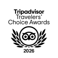 A TripAdvisor “Travelers’ Choice Awards” badge for 2026, featuring a smiling owl and laurel wreath emblem.
