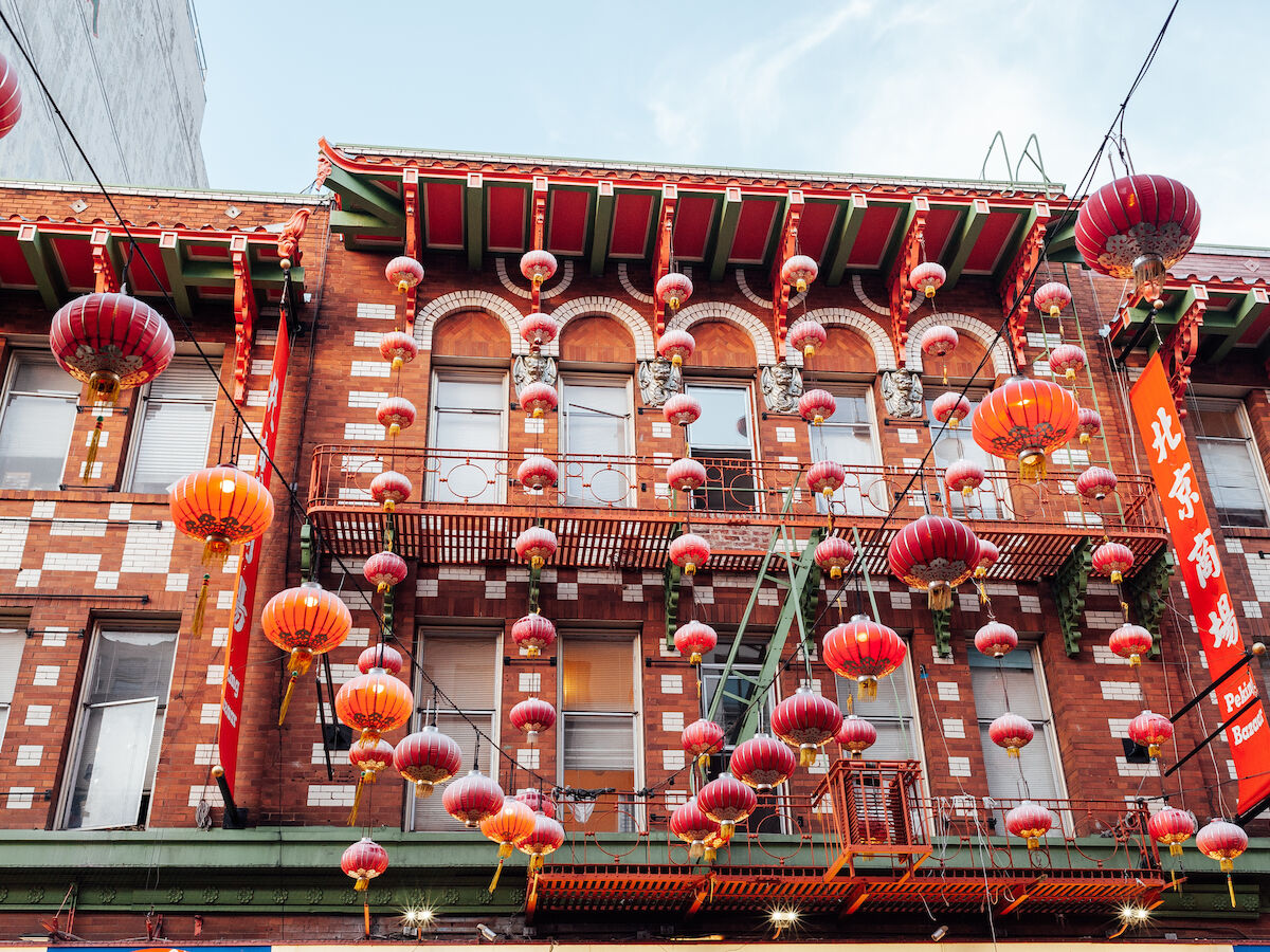 A colorful Chinese rooftop with red brick patterns, hanging lanterns, and festive decorations on a traditional building.